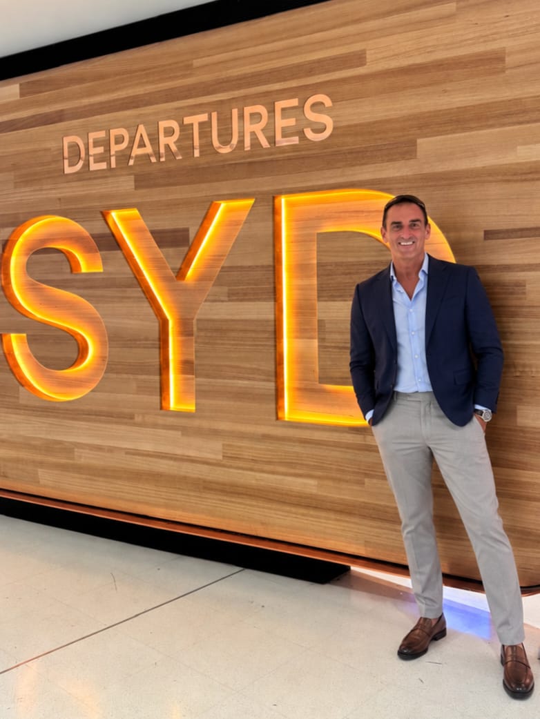 Neil Walters, The Expat Adviser, wearing a navy blazer at an airport departures area